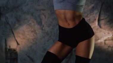Seksi sportif kız, fitness modeli Cam önünde taşır. Bir el saçları ile çalışır ve doğrudan kameraya benziyor