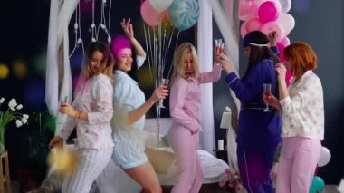Şampanya gülmek ve gülümsemek gözlüklü bir Pijama partisinde Kızlar dans grubu.