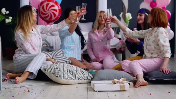 Un groupe de danseuses lors d'une soirée pyjama avec des verres de champagne rire et sourire. Le enterrement de vie de jeune fille bat son plein. De belles femmes s'assoient en cercle et discutent des tendances de la mode — Video