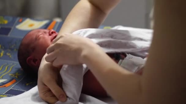 Азіатський новонароджена дитина посміхається, коли swaddle її тіло з памперсів після прийнятих душ. — стокове відео
