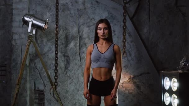 Sportig fitness tjej modell kort med fin kropp tittar på kameran. — Stockvideo
