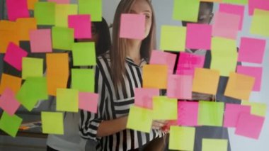 Yaratıcı iş takım birlikte paylaşım veri saat sonra gece geç saatlerde modern Cam ofisinde çalışan beyin fırtınaları. Çok etnik yaratıcı ekibi tüm fikirlerini yapıştırılır beyin fırtınası yapar