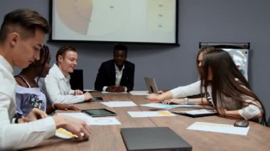Yaratıcı çok etnik gruptan yöneticileri bir grup sökmeye konferans salonunda Yönetim Kurulu toplantısında şirket geçen yıl için kar grafikler. Bir Afrikalı patron