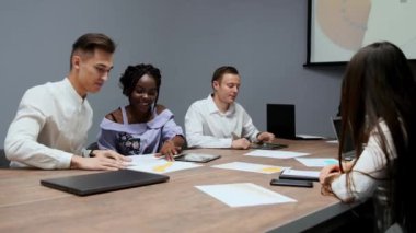 Yaratıcı çok etnik gruptan yöneticileri bir grup sökmeye konferans salonunda Yönetim Kurulu toplantısında şirket geçen yıl için kar grafikler. Bir Afrikalı patron