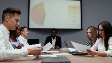 Yaratıcı çok etnik gruptan yöneticileri bir grup sökmeye konferans salonunda Yönetim Kurulu toplantısında şirket geçen yıl için kar grafikler. Bir Afrikalı patron