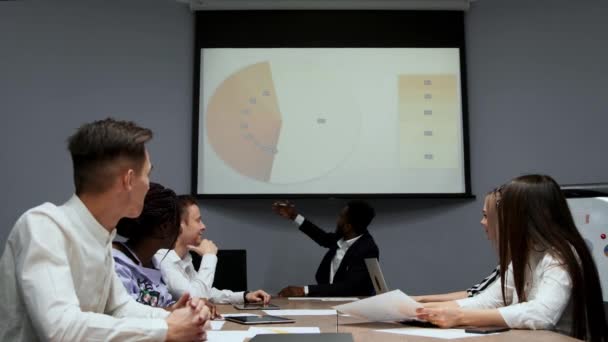 Um grupo multi étnico com um diretor afro-americano conversa e problemas na empresa e discutir a resolução de problemas em um gráfico na tela na sala de conferências A ascensão e queda do — Vídeo de Stock