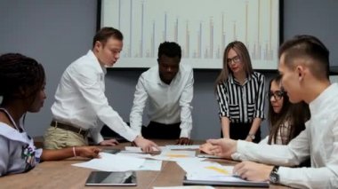 Kendi cryptocurrency proje oluşturma hakkında beyin fırtınası. Bir grup insan ofiste ekonomik yaptırımlar görüşüyorlar. İş geliştirme için yaratıcı fikirler. Ofiste çok etnik gruptan oluşan takım