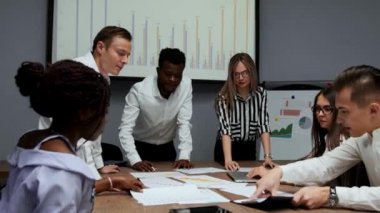 Kendi cryptocurrency proje oluşturma hakkında beyin fırtınası. Bir grup insan ofiste ekonomik yaptırımlar görüşüyorlar. İş geliştirme için yaratıcı fikirler. Ofiste çok etnik gruptan oluşan takım