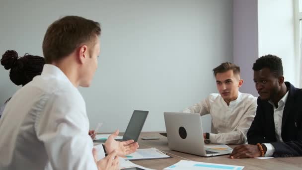 Modern office workers sitting at a laptop solve creative tasks to create new business products. Multi-ethnic groups of men and women — Stock Video