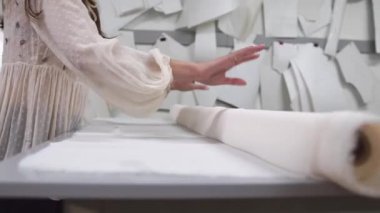 Giysi Tasarımcısı studio tablo üzerinde ölçümler ile çalışıyor. 4 k Uhd vurdu. Closeup dağıtmak yavaş beyaz ve açık renkli dikiş beyaz kumaş skein.