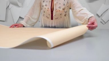 Teyp-line boynunda terzilik stüdyoda ayakta ve tebeşir ve kural ile çizgi çizme ile genç kadın tasarımcı. Gelecekteki giysiler için bir desen atelier kesmek içinde kadın modacı.