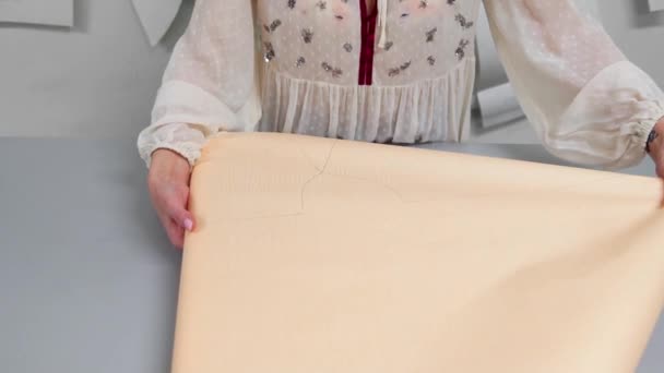 Joven diseñadora femenina con cinta adhesiva en el cuello de pie en el estudio de confección y líneas de dibujo con tiza y regla. La costurera femenina en el taller que corta el patrón para la ropa futura . — Vídeos de Stock