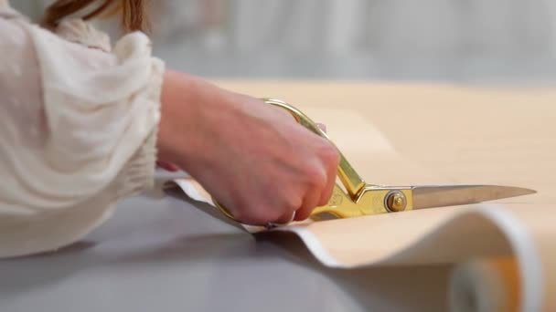 Jonge vrouwelijke ontwerper met tape-lijn aan haar nek permanent in de kleermakerij studio en lijnen met krijt en regel tekenen. Vrouwelijke couturier in atelier uitsnijden van een patroon voor toekomstige kleding. — Stockvideo