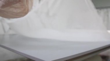 Giysi Tasarımcısı studio tablo üzerinde ölçümler ile çalışıyor. 4 k Uhd vurdu. Closeup dağıtmak yavaş beyaz ve açık renkli dikiş beyaz kumaş skein.