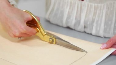 Teyp-line boynunda terzilik stüdyoda ayakta ve tebeşir ve kural ile çizgi çizme ile genç kadın tasarımcı. Gelecekteki giysiler için bir desen atelier kesmek içinde kadın modacı.