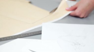 Teyp-line boynunda terzilik stüdyoda ayakta ve tebeşir ve kural ile çizgi çizme ile genç kadın tasarımcı. Gelecekteki giysiler için bir desen atelier kesmek içinde kadın modacı.