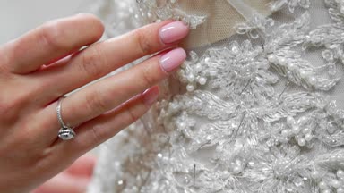 Yakın çekim moda tasarımcısı stüdyosunda gelinler için iğne dantel gelinlik sabitler. Terzi özel bir gelinlik oluşturur. Pins ve iğneler anahat ile güvenli. Küçük özel işletme