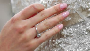 Yakın çekim moda tasarımcısı stüdyosunda gelinler için iğne dantel gelinlik sabitler. Terzi özel bir gelinlik oluşturur. Pins ve iğneler anahat ile güvenli. Küçük özel işletme