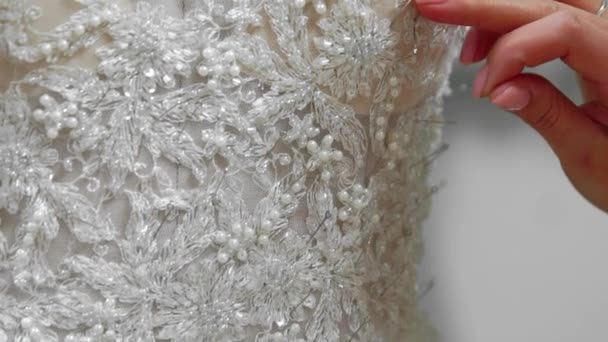 Close-up créateur de mode pour les mariées dans sa robe de mariée en dentelle aiguilles Studio. Seamstress crée une robe de mariée exclusive. Fixer avec des broches et des aiguilles contour. Petites entreprises privées — Video