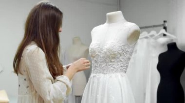 Bir manken giyinmiş bir elbise gelinlik özel sipariş dikiş kumaşlar ve rhinestones tarafından oluşturma bir kız portresi. üretim gelinlik. Küçük iş