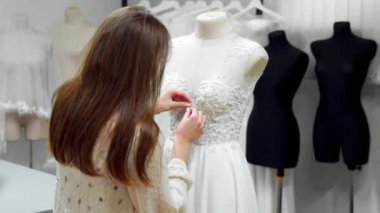 Bir manken giyinmiş bir elbise gelinlik özel sipariş dikiş kumaşlar ve rhinestones tarafından oluşturma bir kız portresi. üretim gelinlik. Küçük iş