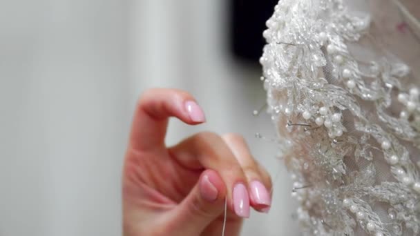 Närbild modedesigner för brudar i hans Studio pins nålar spetsar bröllopsklänning. Sömmerska skapar en exklusiv brudklänning. Säkra med myrkrypningar disposition. Privata småföretag. Sy — Stockvideo