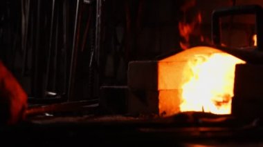 Bir demirci ocağı, alevler fanning araçları kullanarak closeup köz önler, uçan tarafa ağır çekimde kıvılcım. Demirci el Close-Up.