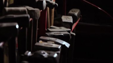 Sağlam Close-Up el alır yavaş çekimde karanlık bir arka plan üzerinde metal çekiç mans. Smith metal ile çalışmak için onun el çekiç alır