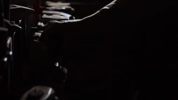 Γκρο πλαν ενός εύρωστου επανδρώνει το χέρι παίρνει ένα μεταλλικό σφυρί σε σκούρο φόντο σε αργή κίνηση. Smith παίρνει το σφυρί του χεριού για την εργασία με μέταλλο — Αρχείο Βίντεο