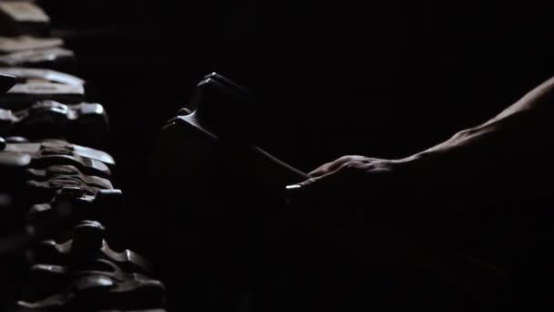 Close-up van een mans hand gooit een hamer en draait het op een donkere achtergrond in de contour licht. Brutale, krachtige concept — Stockvideo