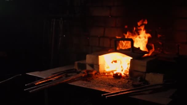 Primo piano di un fabbro ventilatore le fiamme del forno, utilizzando gli strumenti impedisce braci, scintille che volano di lato al rallentatore. Primo piano della mano dei fabbri . — Video Stock
