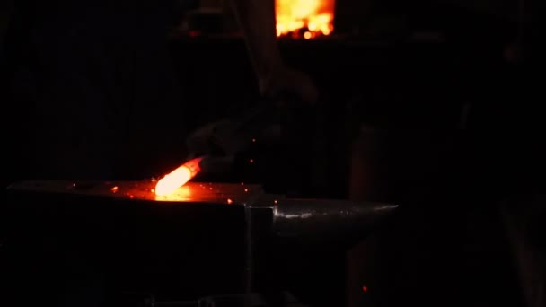 Get hot metal from the furnace to make an arrow tip. Hammer blows on the hot metal. Sparks of metal flying in all directions, slow motion. Ancient craftsmanship. — Stock Video