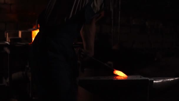 Obtener metal caliente del horno para hacer una punta de flecha. Golpes de martillo en el metal caliente. Chispas de metal volando en todas direcciones, en cámara lenta. Artesanía antigua . — Vídeo de stock