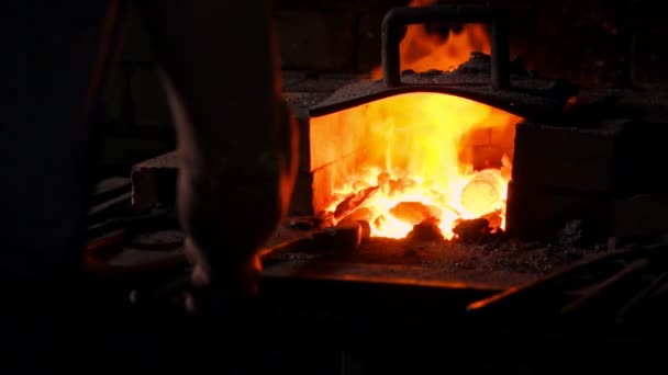 Ottenere metallo caldo dal forno per fare una punta di freccia. Il martello soffia sulla metallo bollente. Scintille di metallo che volano in tutte le direzioni, rallentatore. Artigianato antico . — Video Stock