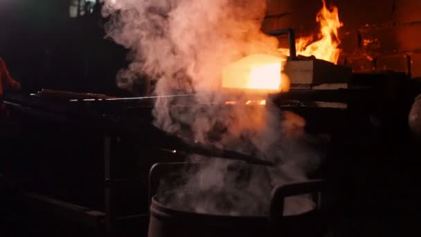 Hardening of the metal by sharp cooling in water. There is steam. The blacksmith tempers a red-hot sword on an old technology. Creation of ancient weapons. Blacksmiths Armory. — Stock Video