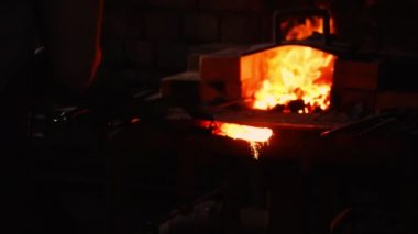 Sıcak metal fırın bir ok ucu yapmak için olsun. Darbeler sıcak metal üzerinde çekiç. Her yöne yavaş uçan metal kıvılcım. Antik işçilik.