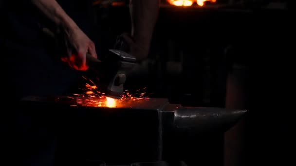 Get out of the furnace hot metal to make a sword war. Master of ancient art creates metal products. In slow motion blacksmiths hammer on red metal flying sparks. — Stock Video