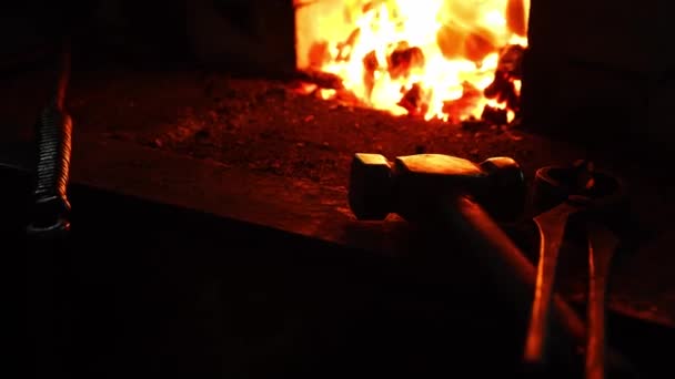 Closeup ενός σιδερά fanning τις φλόγες του φούρνου, χρησιμοποιώντας τα εργαλεία αποτρέπει ΕΛΗ, σπινθήρες που φέρουν στο πλάι σε αργή κίνηση. Γκρο πλαν, σιδεράδες χέρι. — Αρχείο Βίντεο