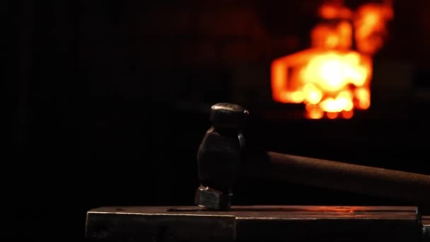 Close-up van een smid wakkeren de vlammen van de oven, met behulp van de tools voorkomt sintels, vonken vliegen naar de kant in slow motion. Close-up van smeden hand. — Stockvideo