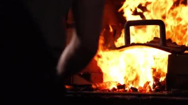 Fırın alevler yanan arka planda bir demirci çekiç closeup.