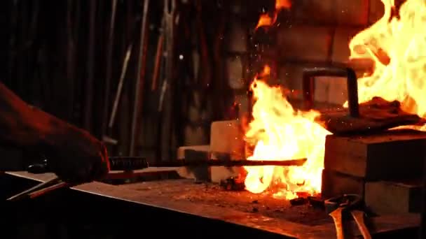 Крупный план кузнеца, раздувающего пламя печи, с помощью инструментов предотвращает попадание углей, искр в сторону в замедленной съемке. Крупный план руки кузнецов . — стоковое видео
