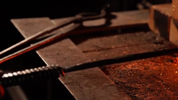 Close-up van een smid wakkeren de vlammen van de oven, met behulp van de tools voorkomt sintels, vonken vliegen naar de kant in slow motion. Close-up van smeden hand. — Stockvideo