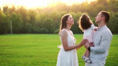 Mutlu genç aile yaz sahada yürüyüş çocuk ile. Sağlıklı anne, baba ve küçük kızı kız doğanın keyfini birlikte, açık havada. Günbatımı.