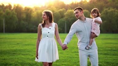 Mutlu genç aile yaz sahada yürüyüş çocuk ile. Sağlıklı anne, baba ve küçük kızı kız doğanın keyfini birlikte, açık havada. Günbatımı.