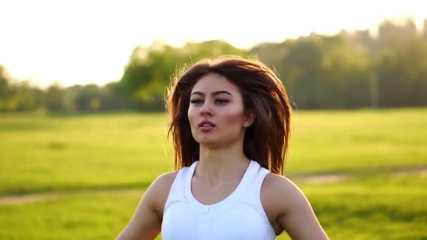 Instructeur de fitness femme faisant des sauts de jacks d'exercice dans le parc vert — Video