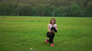 Atletik kadın kasları kırsal yolda günbatımı sırasında germe..