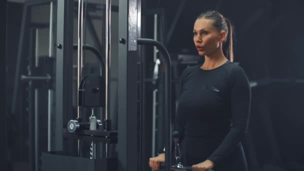 La hembra bombea bíceps en el gimnasio — Vídeo de stock