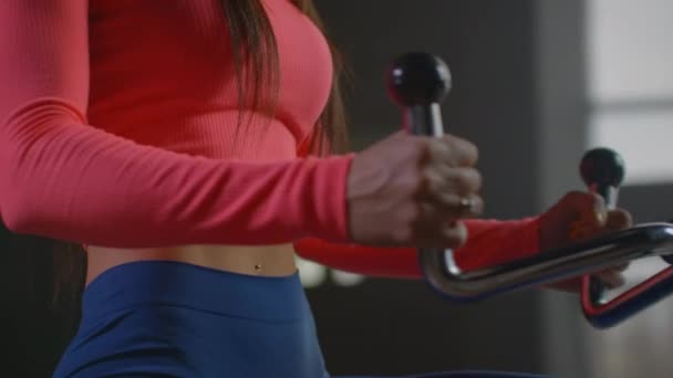 Zamknij: Okrągły trening na siłowni dla idealnego ciała. Piękna młoda kaukaska kobieta zmęczona ćwiczeniami na wioślarzu w siłowni z osobistym trenerem slow motion. — Wideo stockowe