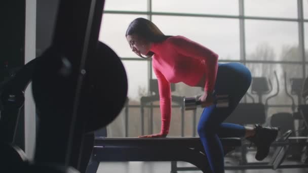 Woman is doing exercise with dumbbell in the gym — Stock Video