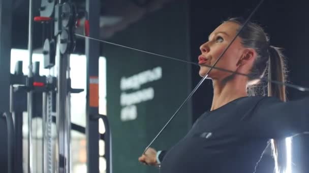 Jovem do sexo feminino realiza um treinamento circular no ginásio — Vídeo de Stock